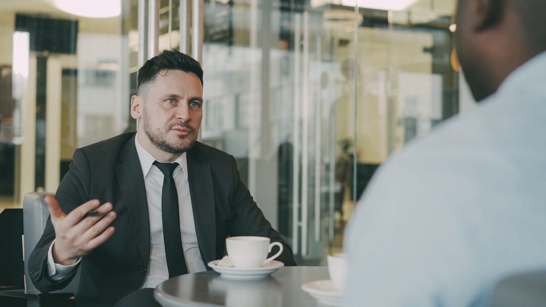 Journalist taking notes during an expert interview in an office setting