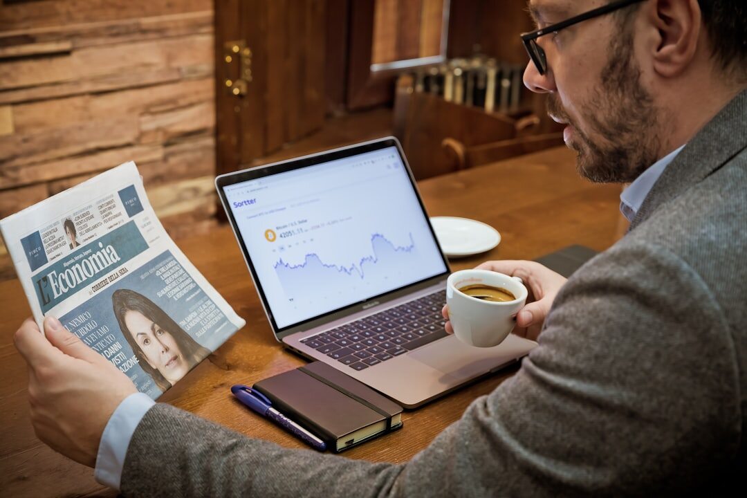 Journalist fact-checking information on multiple screens with documents spread out